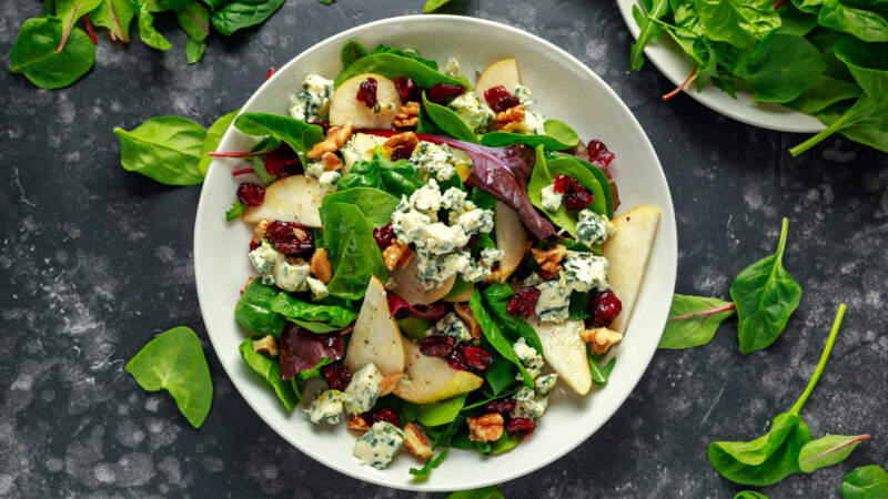 Fresh pears, blue cheese salad with vegetable green mix, walnuts, cranberry. healthy food.