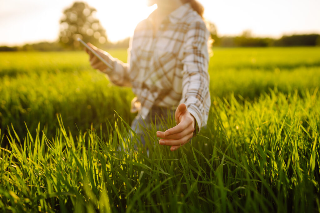 Woman in a field with a device.