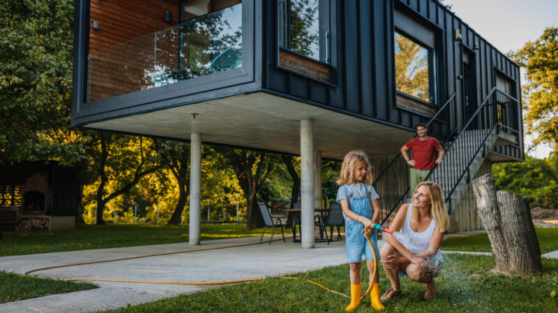 Child with hose and parents on a fire resistant lawn